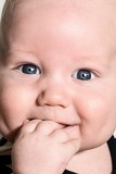 Close-up shot of Baby Oscar's face putting his hand in his mouse