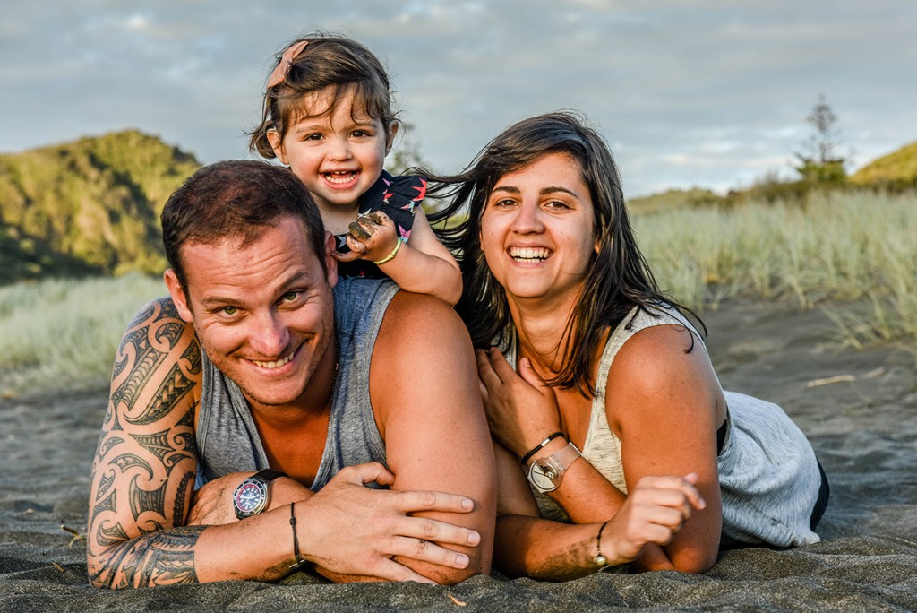 Family pause for camera on NZ beach at sunset