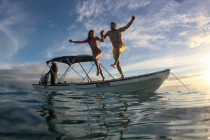 Couple jumping from the boat to the sea