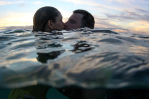 Couple kissing over the water at sunset in Fiji