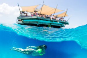 Cloud 9 floating bar and woman swimming sideways over under water photography in Fiji by Anais Photography