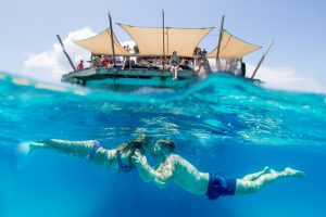 Over under shot with Cloud 9 bar on the top and couple kissing under the water in Fiji by Anais Photography