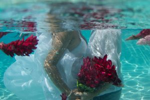couple holding the bouquet under the water in the pool in Fiji by Anais Photography
