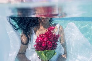 bride holding her bouquet under the water in Fiji by Anais Photography