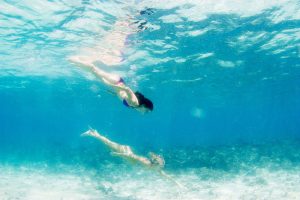 Two women swimming underwater