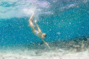 Blurred photo of woman reaching toward the bottom of the ocean Cloud 9 in the Mamanuca islands in Fiji
