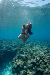 Woman underwater by a coral wall