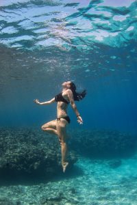 Woman underwater by a coral wall