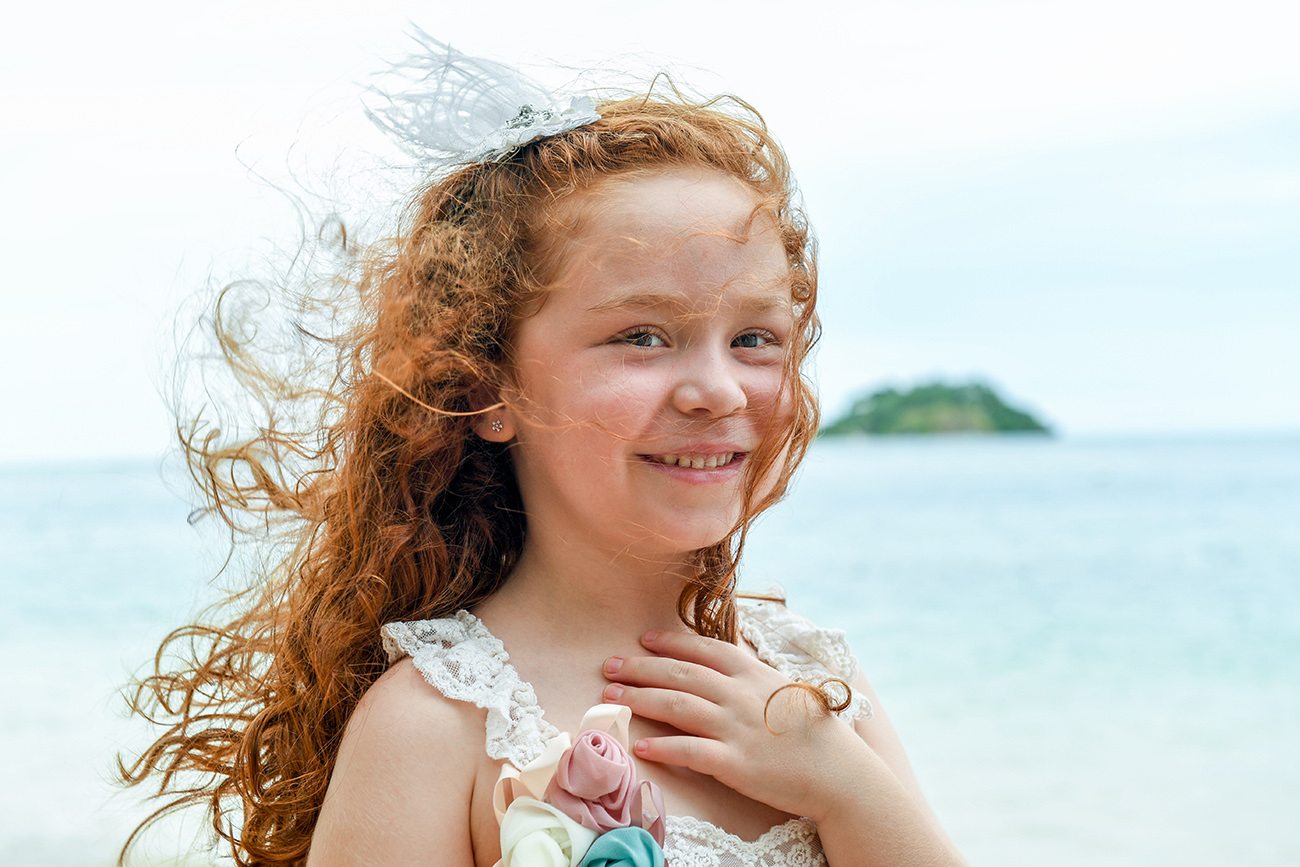Red head girl smiles at camera in family photoshoot in Malolo Island Resort Fiji