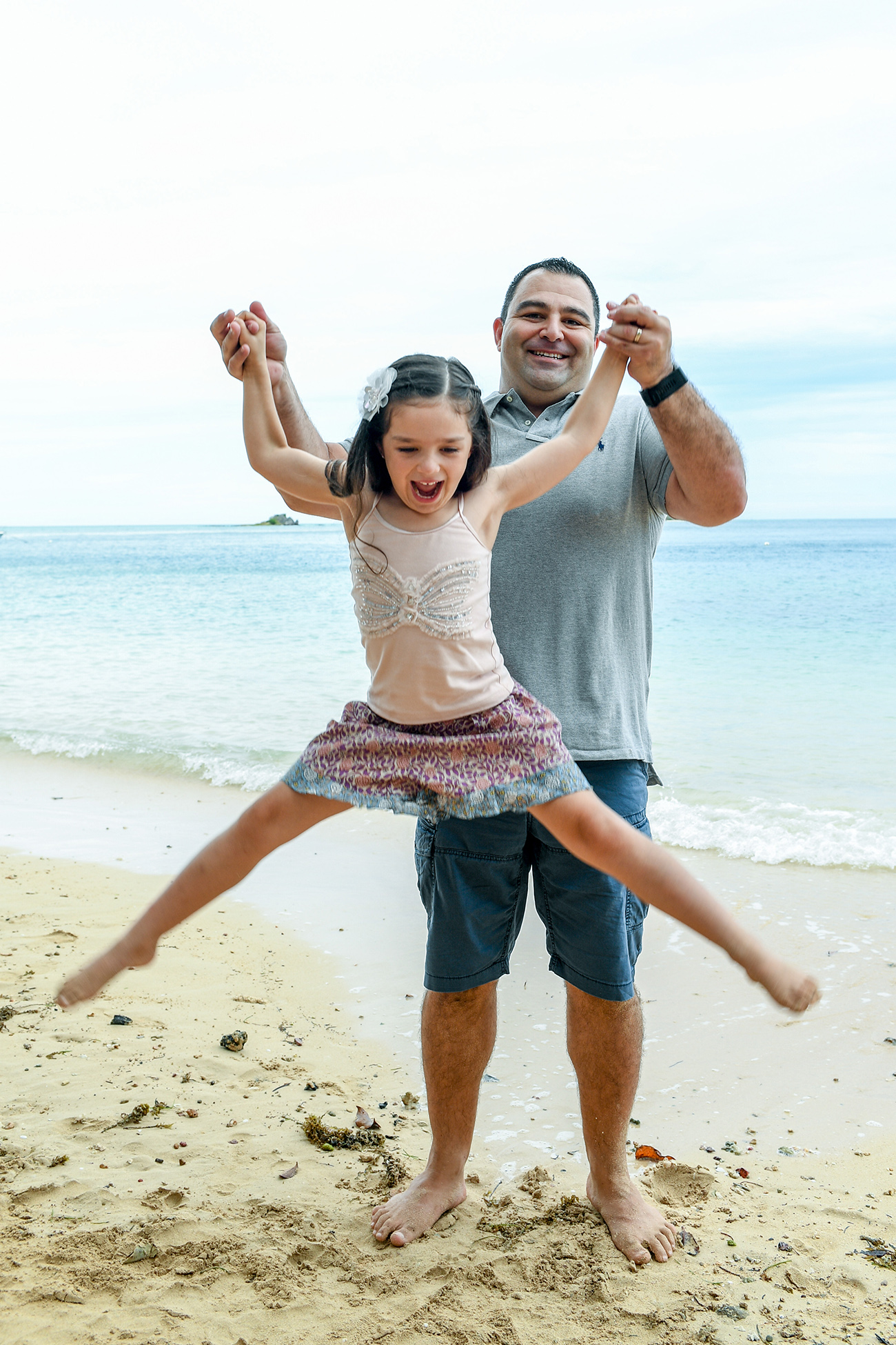 Father and daughter play on the beach in Malolo Island Resort Fiji