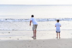 Father and son play on the beach in Natadola Fiji during sunset