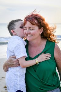 son kisses Red haired mum on beach in Fiji
