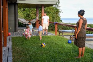 Triplets play with their dad during the Fiji family vacation
