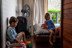 Triplets seated on the bed during family vacation Fiji