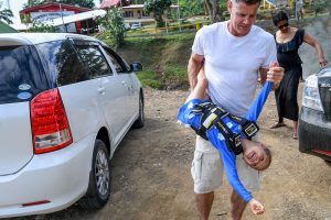 Dad carries daughter upside down during Fiji family vacation