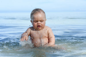 Gorgeous infant playing in the ocean