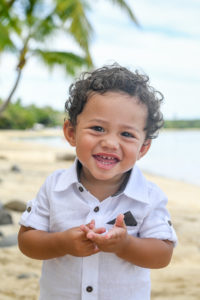 Cute laughing Polynesian boy with curly hair