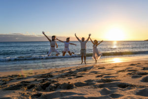 The family leap frogs against the sunset at Fiji