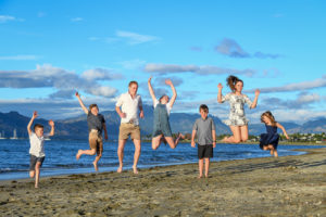 A group of kids leap in the air on the beach