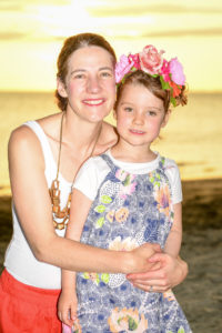 A mother hugs her daughter wearing a flower crown