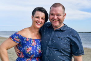 A loving couple in blue smile at the camera at Natadola Fiji