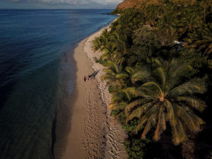 An aerial shot of the family strolling on the beach strip at Vomo Island Fiji