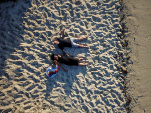 An aerial view of the family making snow angels in the sand