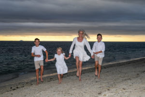 family photoshoot at the Outrigger Fiji. Mother and children running at the beach
