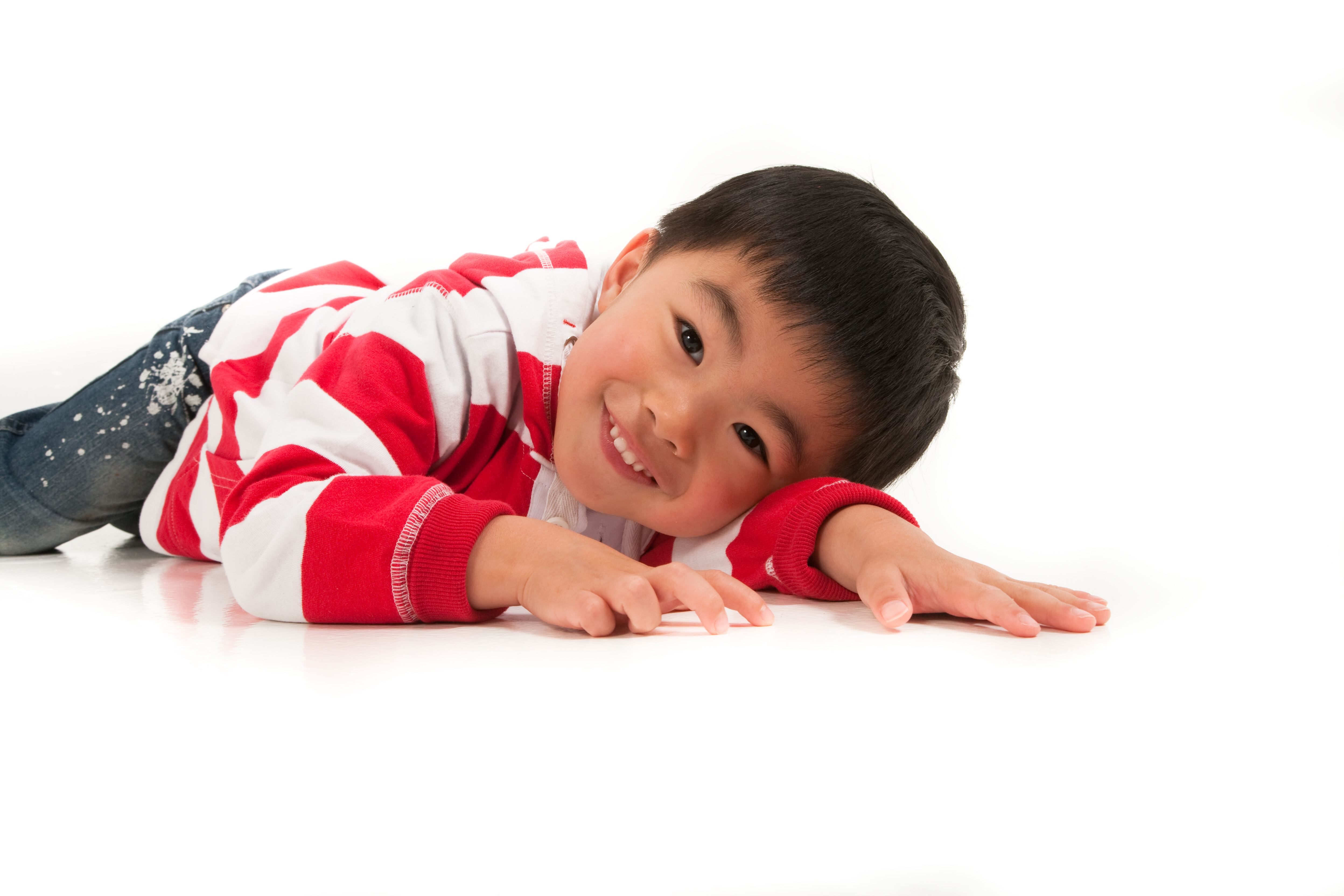 asian little boy lied down happy with big smile hand forward Auckland photoshoot in studio, nz