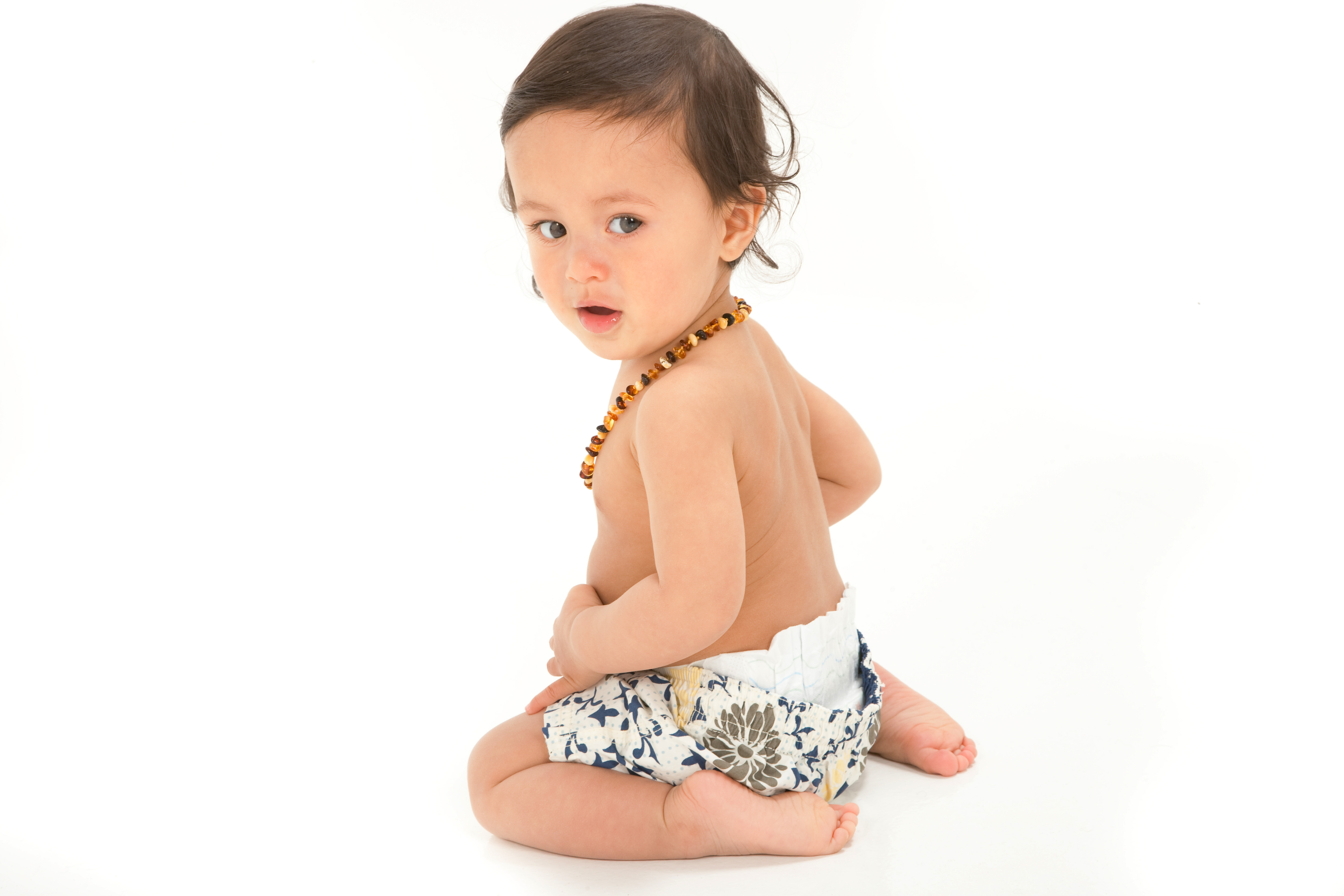 bewildered baby boy from back in studio photoshoot topless and white short