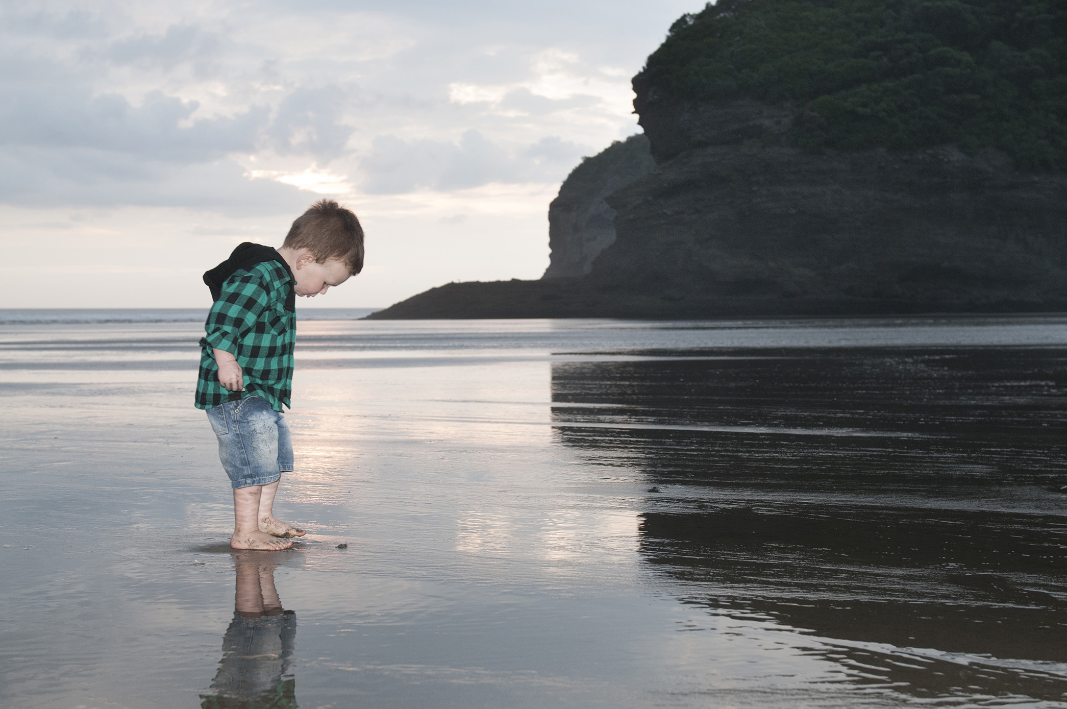 Bethells beach, Reflection on send child little boy photoshoot by Anais Photography, Auckland