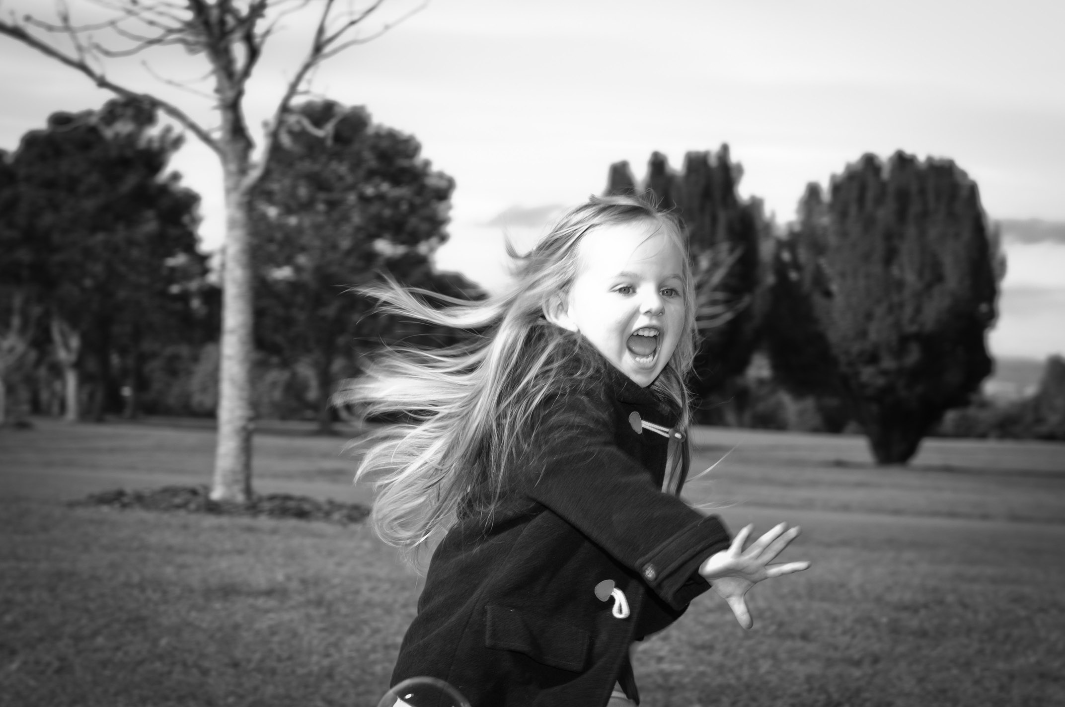 Professional portrait of young girl in movement black and white in One Tree hill Park, Auckland, New Zealand