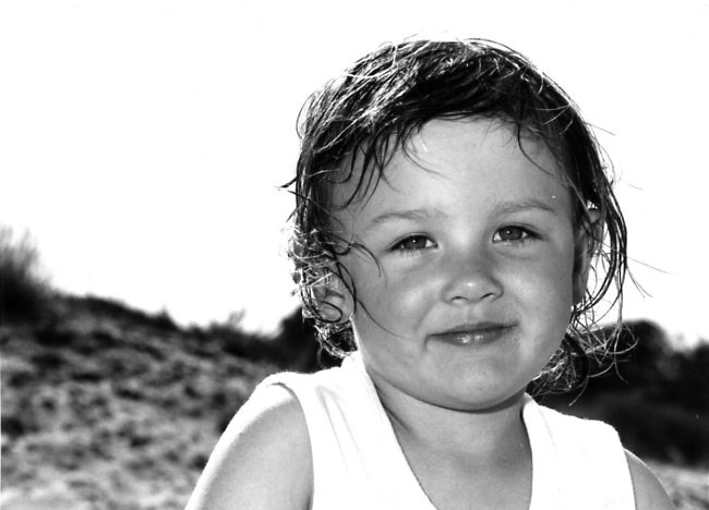 Wet hair toddler little girl by La Badine beach in Hyeres, Var, France. Beautiful gaze by Anais Chaine Photography.