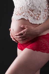 Closeup on baby bump lace top red short pregnancy photoshoot by Anais Chaine Auckland Photographer