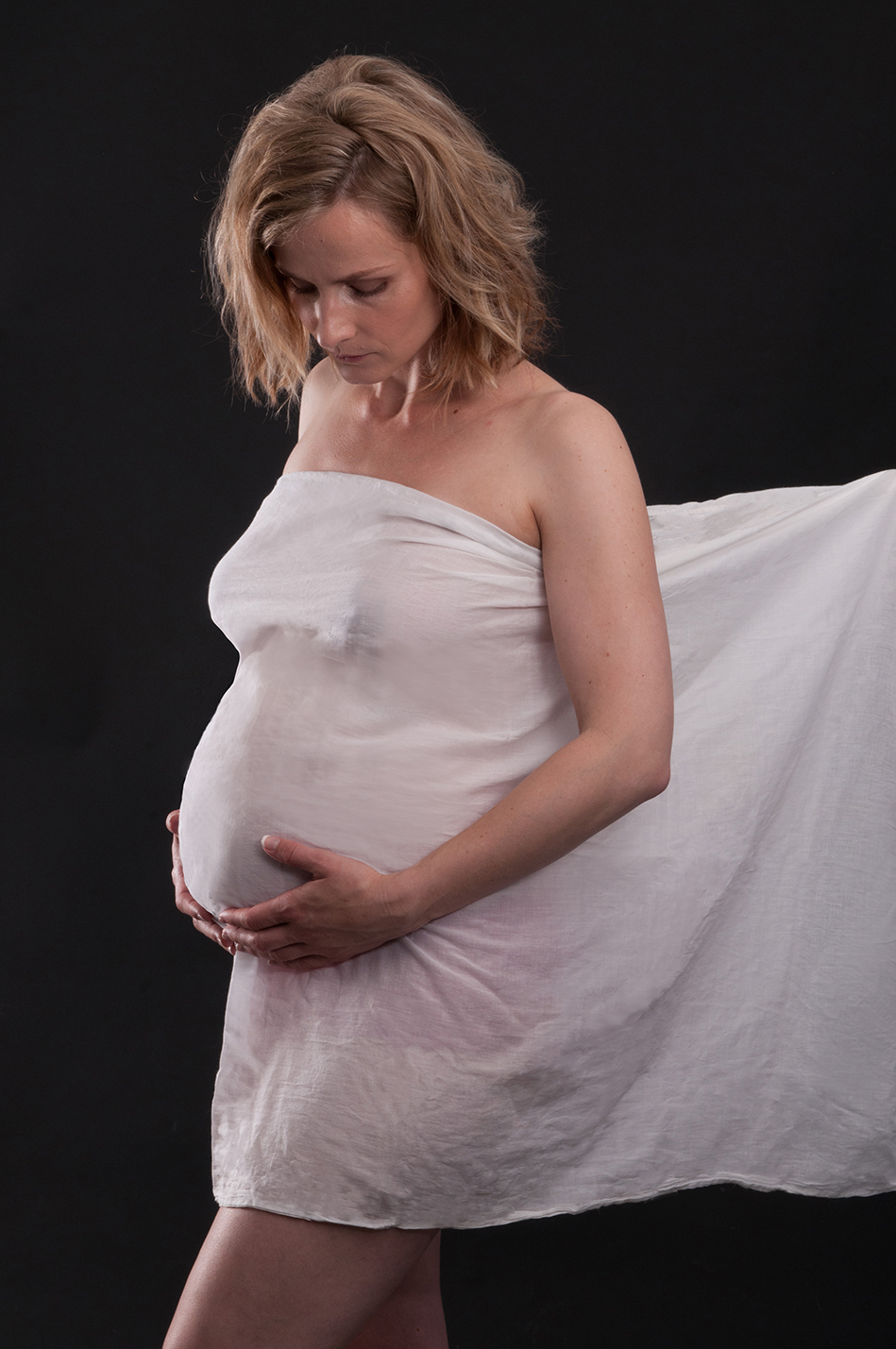 Pregnant woman wrapped Cotton Sheet on baby bump by Anais Chaine Auckland Photographer