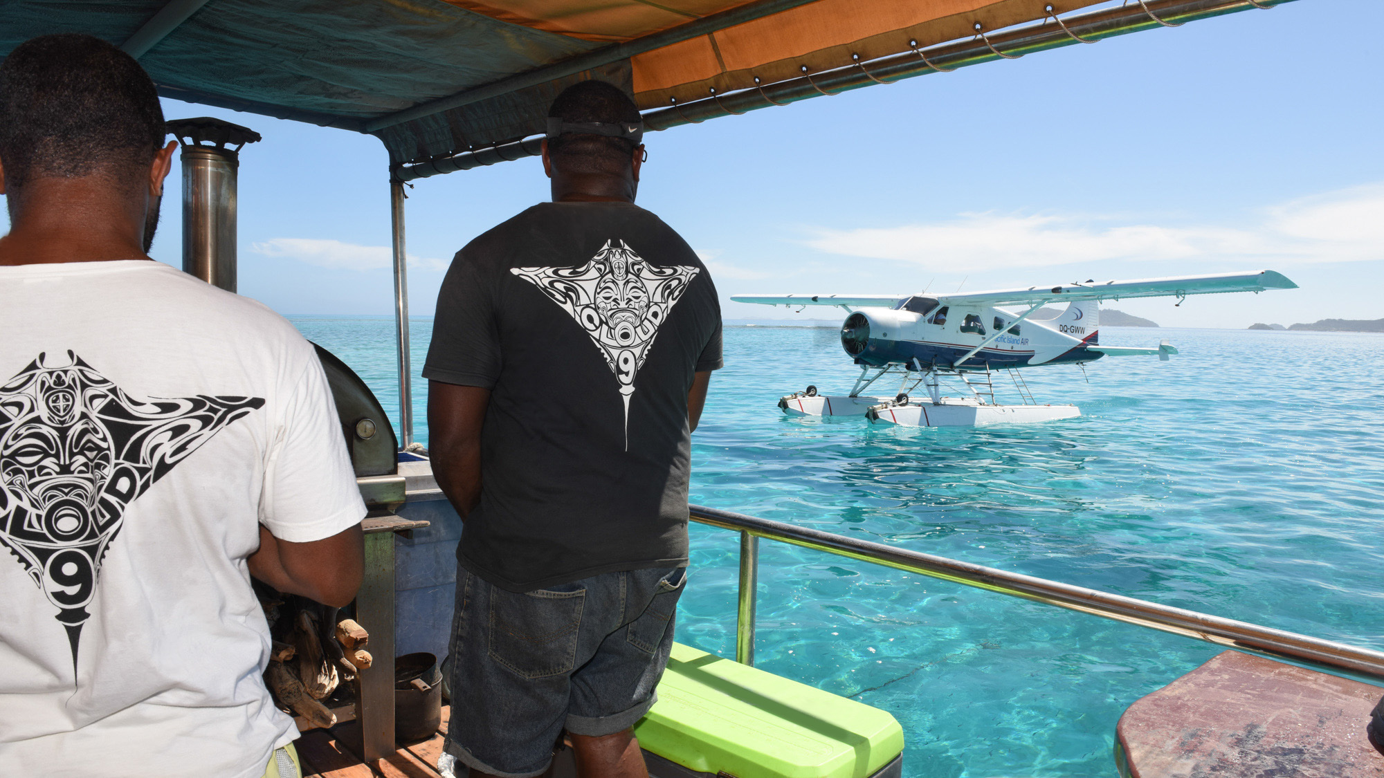 Composition with Cloud 9's team on the left and the seaplane on the right wearing tee shirt with Logo