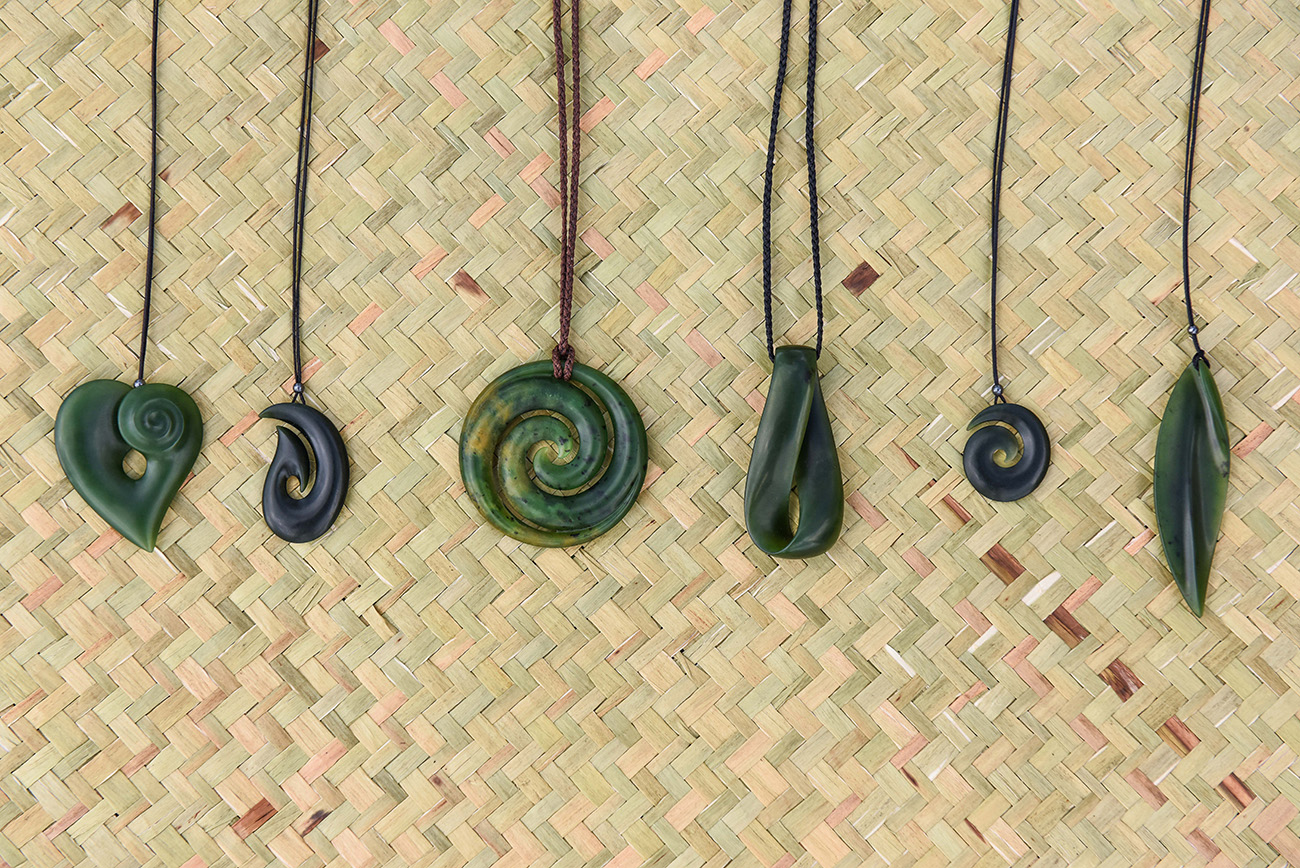 On a wicker carpet a variety of greenstone necklace aligning