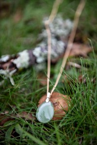 On the grass a greenstone necklace putting down a little mushroom