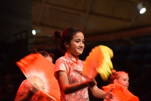 A girl dancing gracefully with a yellow fan traditional chinese dance