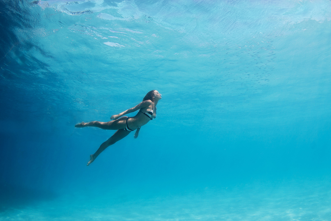 Woman swimming underwater in the pacific ocean