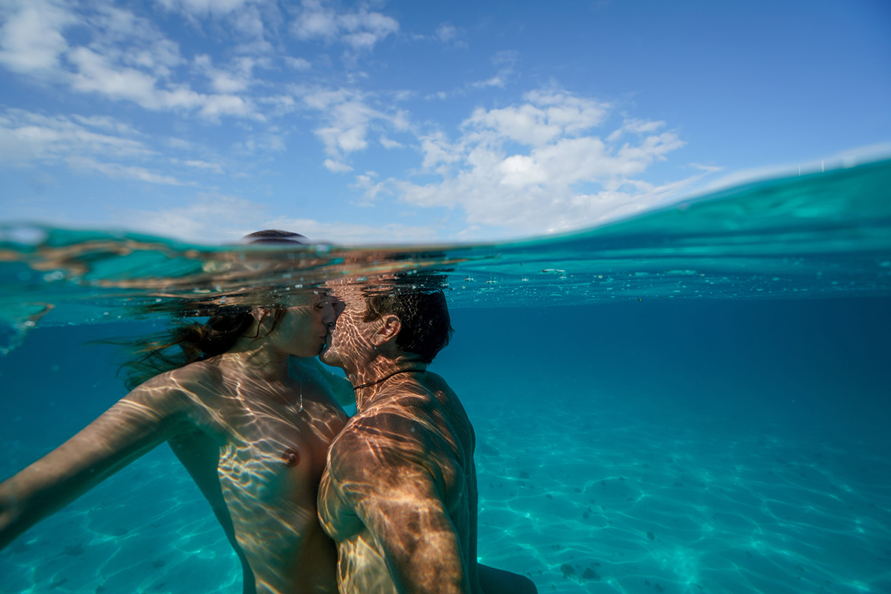 Nude couple kissing underwater in Fiji