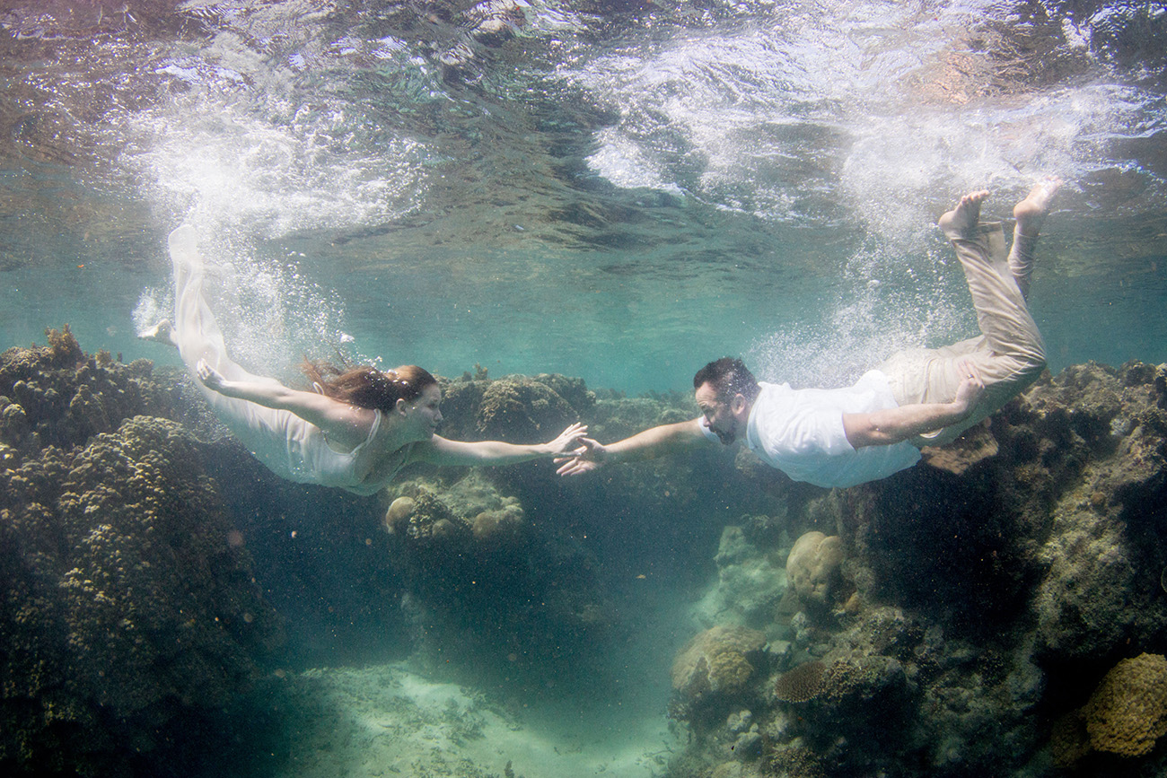 Couple swimming underwater for trash the dress photoshoot in Fiji