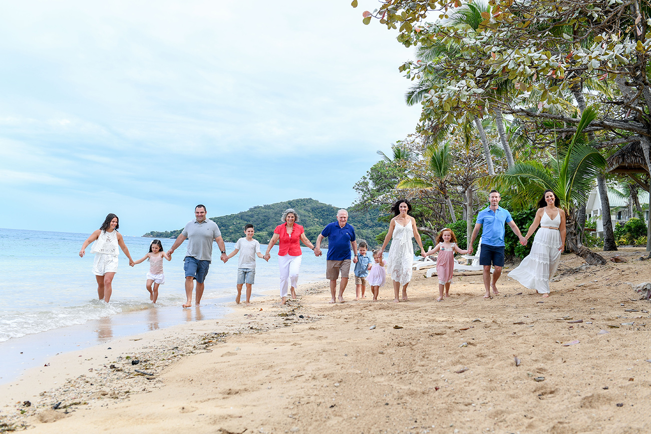 Group family stroll on the beach at Malolo Island Resort Fiji