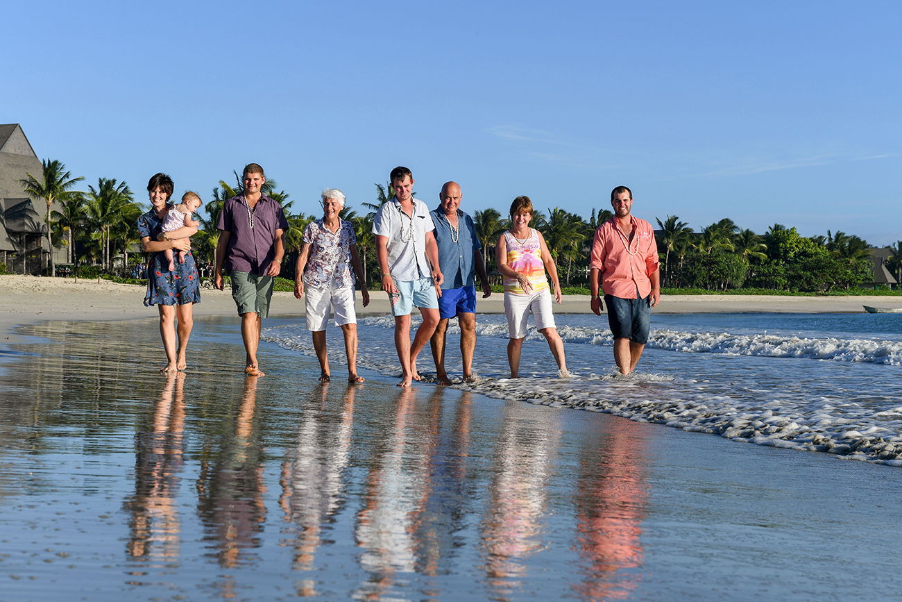 3 generations of family stroll in the ocean at Natadola beach Fiji