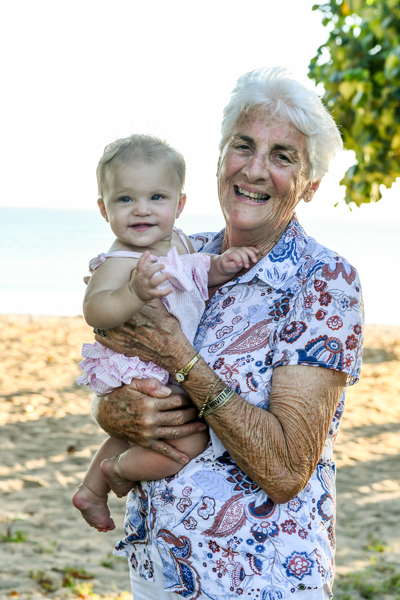 Grandma and baby granddaughter laugh on 3 generations photoshoot on beach in Natadola Fiji