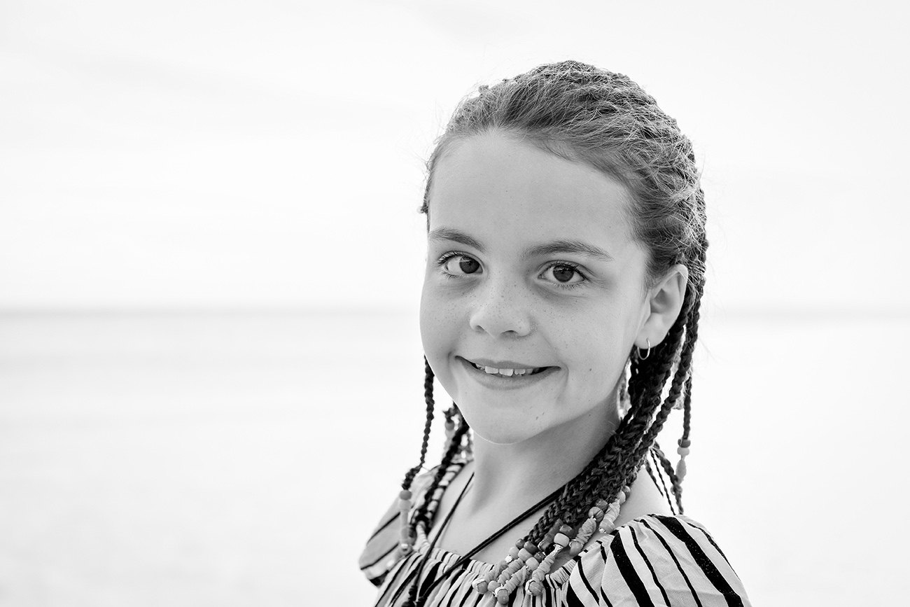 Black and white picture of cute young girl in braids on the beach