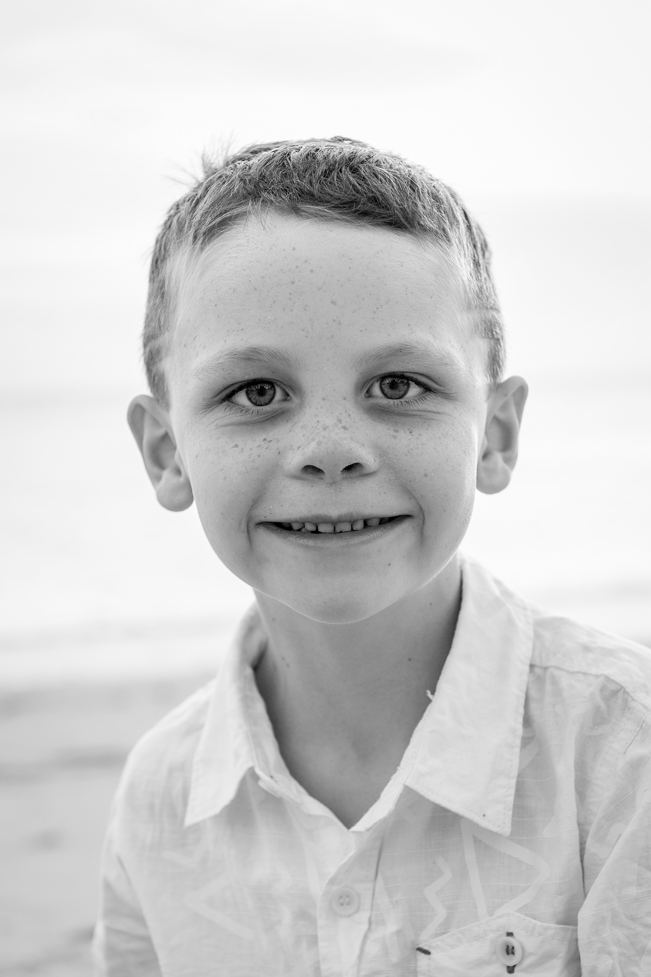 Black and white picture of young boy on the beach