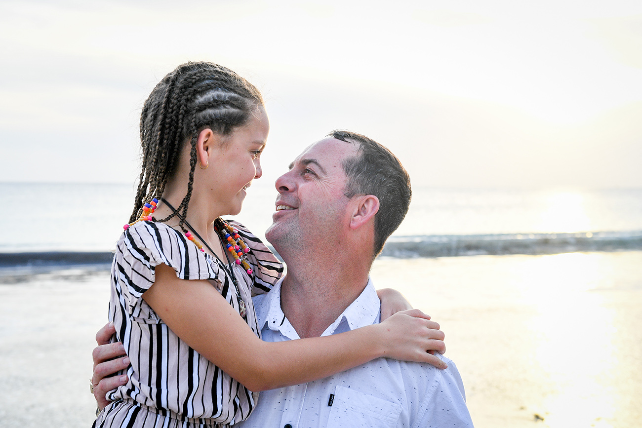 Braided daughter and father look into each others eyes in family beach photography