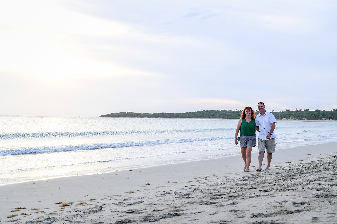 Husband and wife stroll along the beach in Fiji family photography