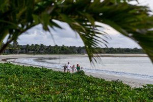 Wideshot of family with palm trees in the foreground on the Natadola beach Fiji